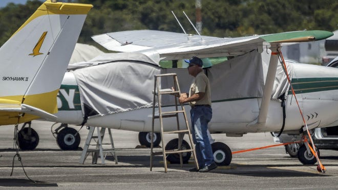 A man tightens ground straps on an airplane at Palm Beach County Park Airport Thursday in unincorporated Palm Beach County. Forecasters are indicating there may be tropical storm force winds in the county beginning early Saturday morning from Tropical Storm Isaias.