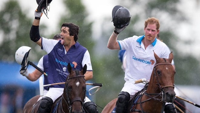 Nacho Figueras and Prince Harry acknowledge the crowd after competing in a charity polo match in Wellington, Florida on May 4, 2016. (Allen Eyestone / The Palm Beach Post)