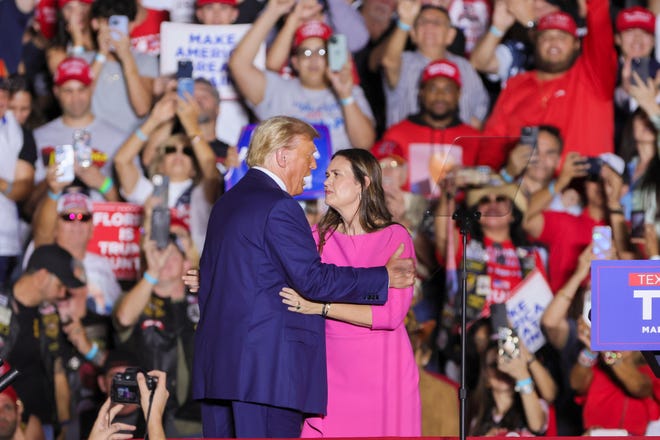 Former President Donald Trump and Arkansas Governor Sarah Sanders meet on stage during a rally at Ted Hendricks Stadium at Henry Milander Park in Hialeah, Florida, Wednesday, November 8, 2023.
