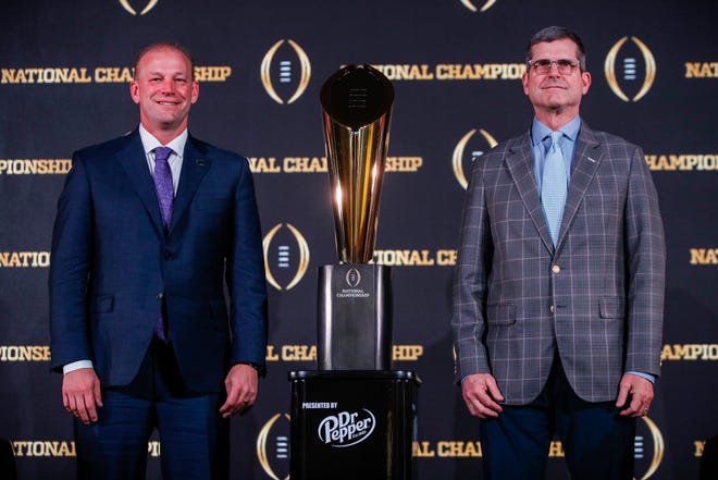 Washington head coach Kalen DeBoer, left, and Michigan head coach Jim Harbaugh pose for a photo with the national championship trophy during a news conference at Liberty Hall in Houston on Sunday, Jan. 7, 2024.
