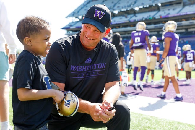 Sep 9, 2023; Seattle, Washington, USA; Washington Huskies head coach Kalen DeBoer talks with a young fan after signing an autograph before a game against the Tulsa Golden Hurricane at Alaska Airlines Field at Husky Stadium. Mandatory Credit: Joe Nicholson-USA TODAY Sports