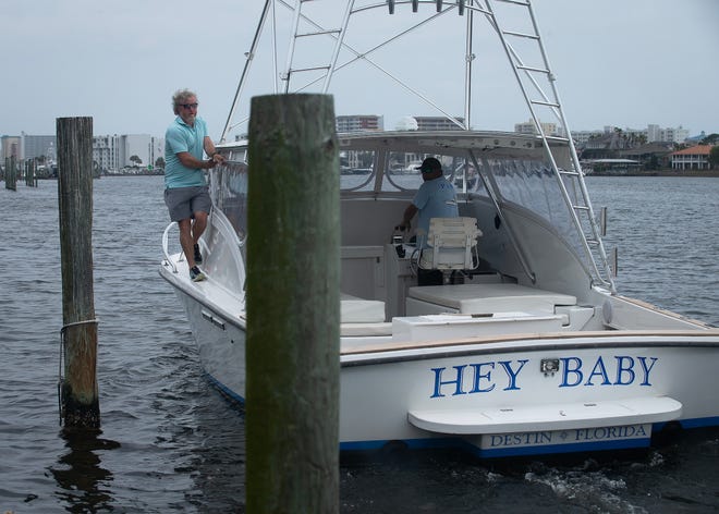 Eddie Morgan, left, owner of Harbor Docks, a family-owned marina and seafood restaurant in Destin, Fla., and Kevin Moak, captain, maneuver the 30-foot 1974 G&S boat "Hey Baby" April 1, 2024.