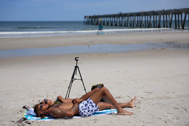 Easy Ash, foreground, of Gainesville, Fla. and girlfriend Laquishia Ferguson of Williston, Fla. view their first eclipse during the solar eclipse Monday, April 8, 2024 at Jacksonville Beach. According to Univision.com Jacksonville Beach experienced 63.8% totality. Ash said he came for “spiritual reasons.” Ferguson said, “I’m wowed.”
