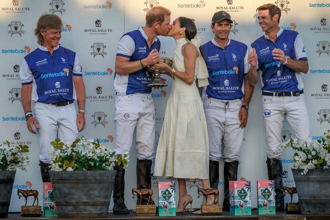Duchess of Sussex Meghan Markle and Prince Harry, Duke of Sussex share a kiss after she presented him and his team with the champions trophy after a polo play at Grand Champions Polo in Wellington, Fla., on April 12, 2024