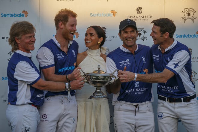 Left to right: Sentebale/Royal Salute players Dana Barnes, Duke of Sussex Prince Harry and his wife Meghan Markle, Adolfo Cambiaso and Malcolm Borwick hold the champion's trophy at Grand Champions Polo in Wellington, Fla., on April 12, 2024