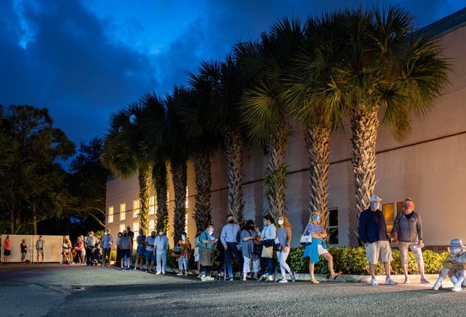 Voters wait in line before sunrise as they wait for the polls to open the during the first day of early voting at the Palm Gardens Branch Library in Palm Beach Gardens , Florida on October 19, 2020. (GREG LOVETT / THE PALM BEACH POST)
