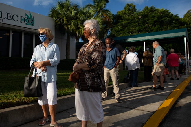 Naples residents Mary Wassmen, left, and Josephine Violette wait to cast their votes during the first day of early voting at the Collier County Government Center in East Naples on  Monday, Oct. 19, 2020.