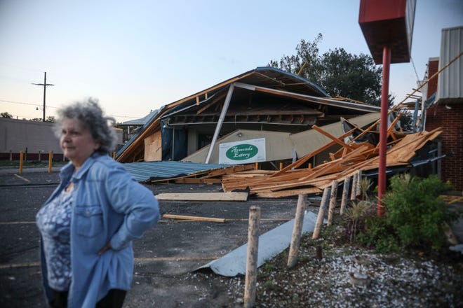 A woman stands in front of a destroyed restaurant after Hurricane Zeta on October 29, 2020, in Chalmette, Louisiana. A record seven hurricanes have hit the gulf coast in 2020 bringing prolonged destruction to the area.