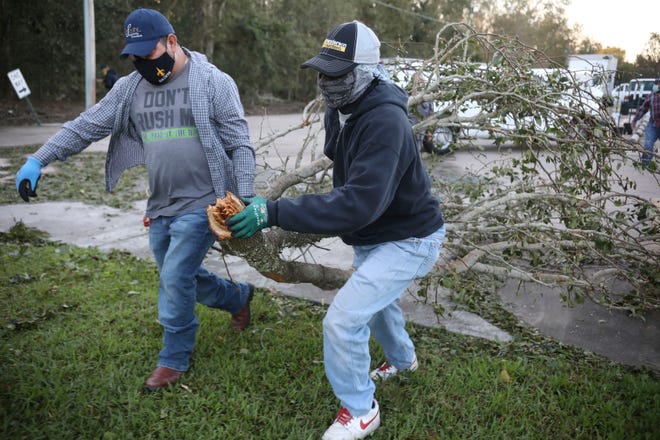 Workers clear debris from Hurricane Zeta at St Bernard Middle School on October 29, 2020, in St Bernard, Louisiana. A record seven hurricanes have hit the gulf coast in 2020 bringing prolonged destruction to the area.
