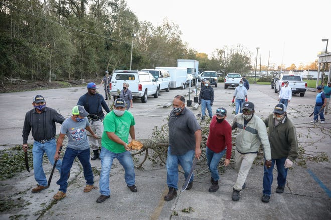 Workers clear debris from Hurricane Zeta at St Bernard Middle School on October 29, 2020, in St Bernard, Louisiana. A record seven hurricanes have hit the gulf coast in 2020 bringing prolonged destruction to the area.