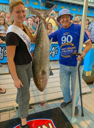 Rob Webster, 90, landed this 70.8-pound amberjack while fishing aboard the Outta Line with Capt. Trey Windes on Day 1 of the Destin Fishing Rodeo in 2022. His catch made it on the leaderboard in the Senior Division. Also pictured is Miss Destin Ella Kathryn Campbell.