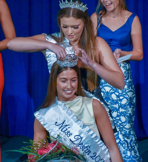 Miss Destin 2022 Ella Kathryn Campbell assists Carrington Phillips with her new crown as Miss Destin 2023 on Saturday night. Phillips is a senior at Destin High School.